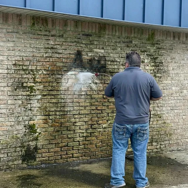 Concrete sidewalk being power washed clean showing dramatic before and after