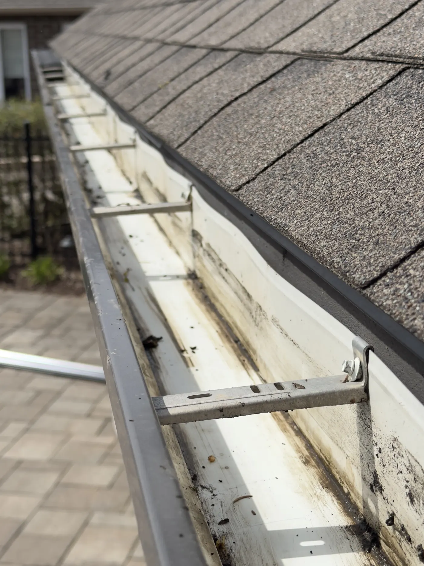 Open gutter clogged with shingle grit and debris before gutter guard installation in Kitchener